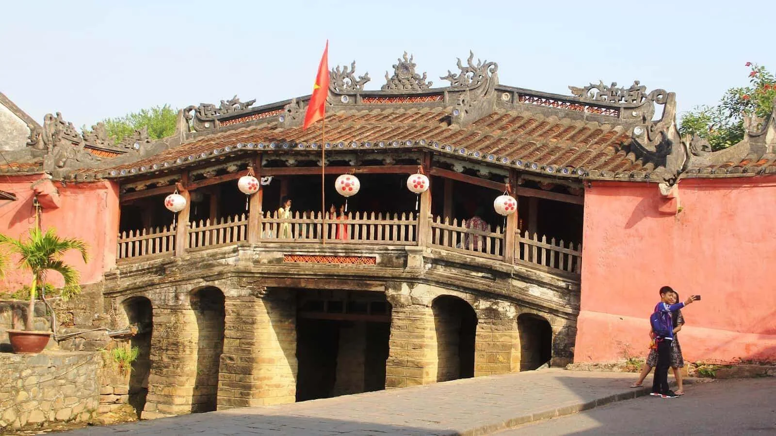 The iconic Japanese Covered Bridge (Chua Cau) featuring unique architectural details spanning a small canal in Hoi An