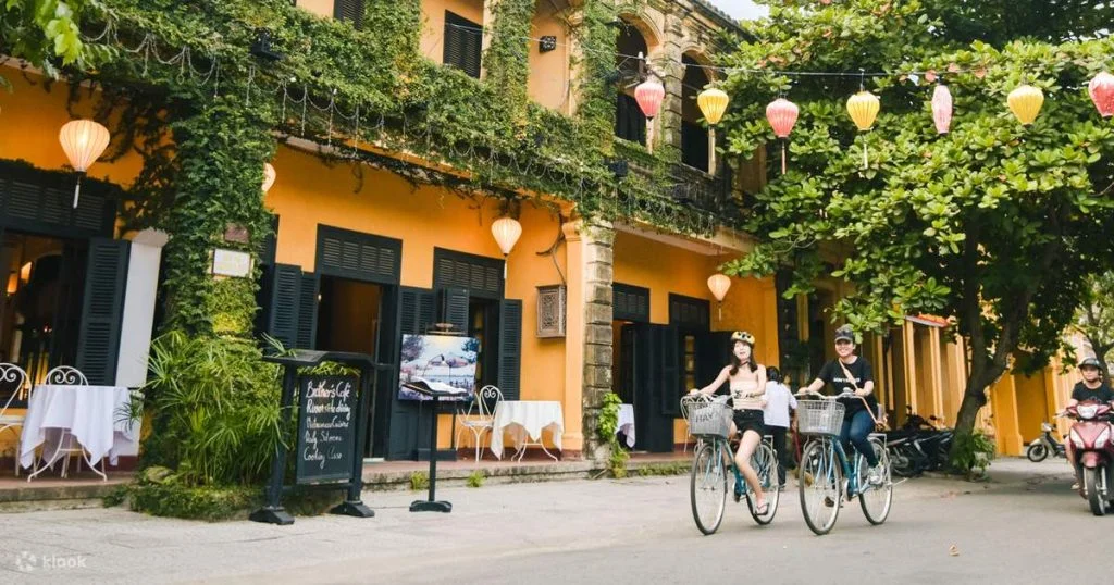 Tourists riding bicycles through the lush green rice paddies and peaceful rural paths of Hoi An.