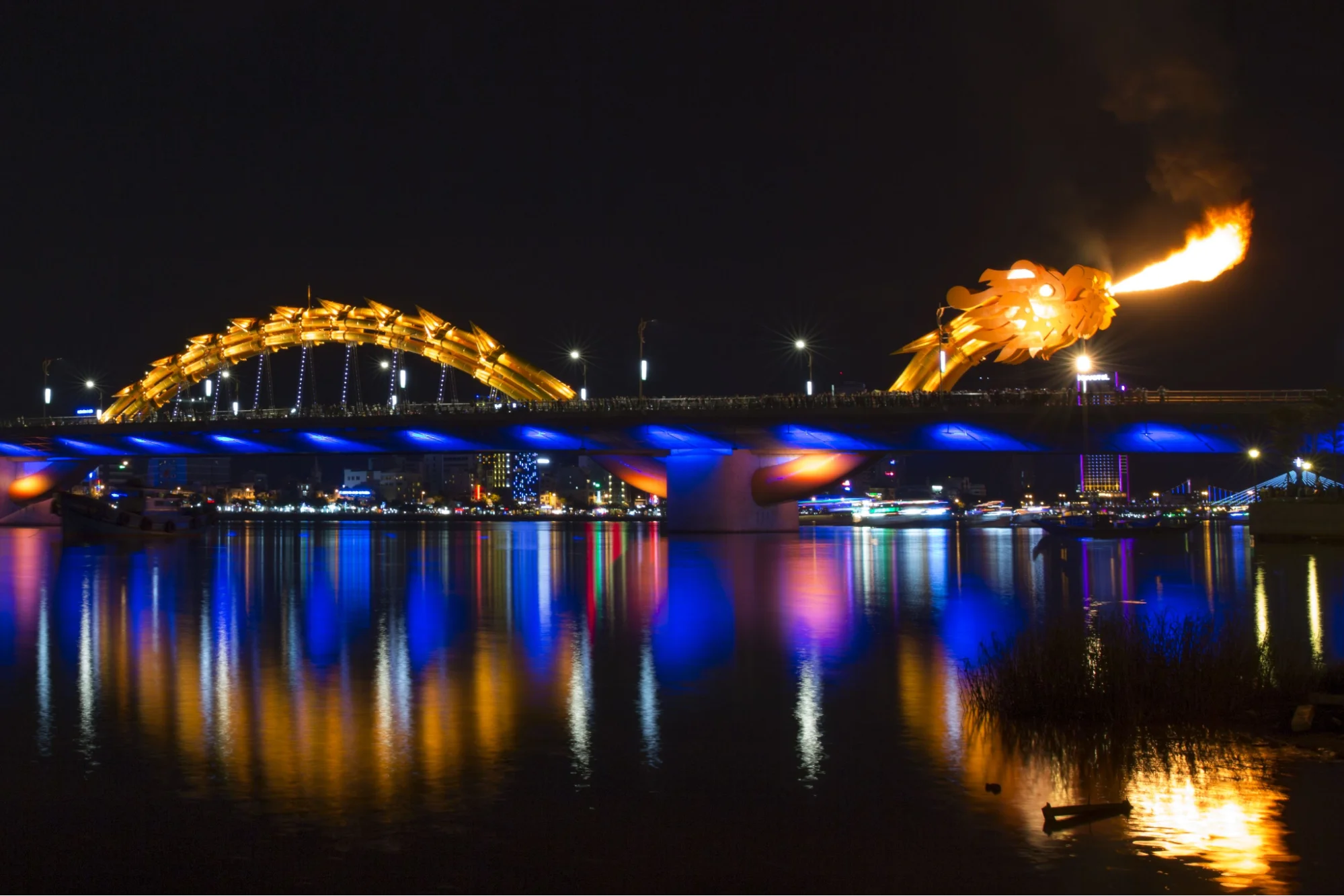 The iconic yellow Dragon Bridge spanning the Han River, breathing fire during the weekend show in Da Nang.