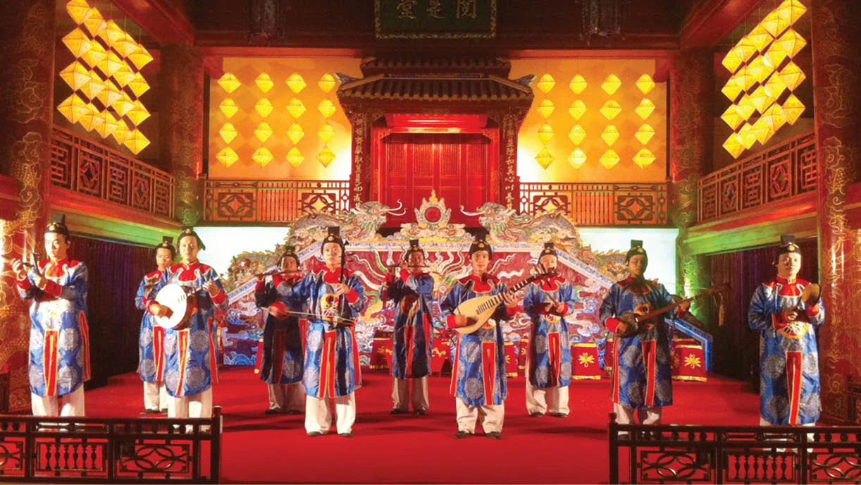 Musicians wearing traditional royal costumes performing Nha Nhac Vietnamese court music with ancient instruments