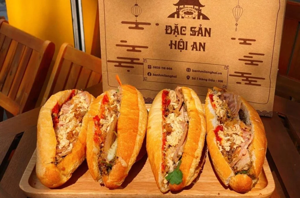 A close-up of a crispy Vietnamese baguette (Banh Mi) filled with grilled meat, pate, and fresh herbs in Hoi An.
