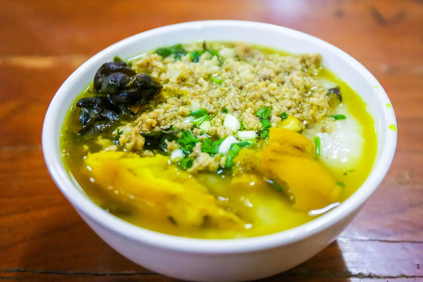 A steaming bowl of Au Tau porridge topped with minced pork and herbs in Ha Giang.