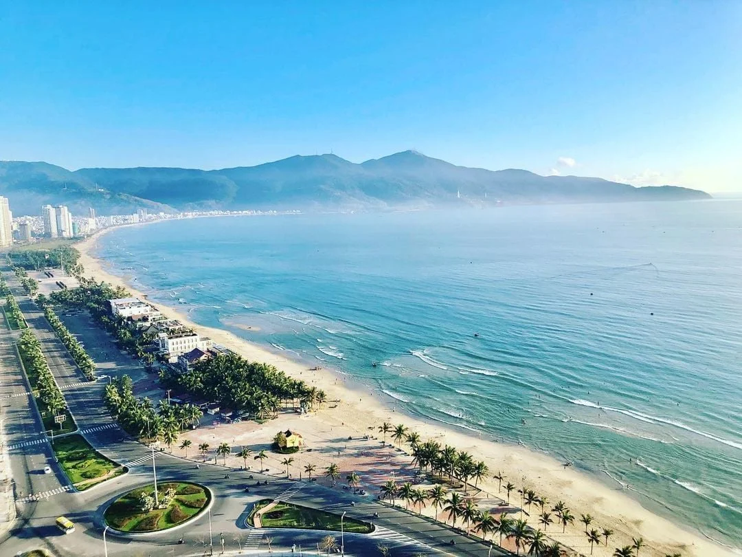 Travelers relaxing on My Khe Beach with clear blue waves in Da Nang