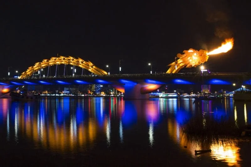 : Dragon Bridge breathing fire over the Han River at night.