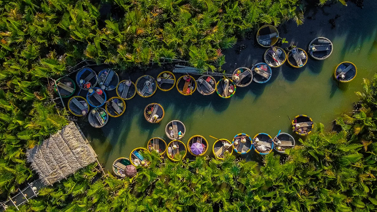 Tourists riding round bamboo basket boats in Bay Mau Coconut Forest, Hoi An.