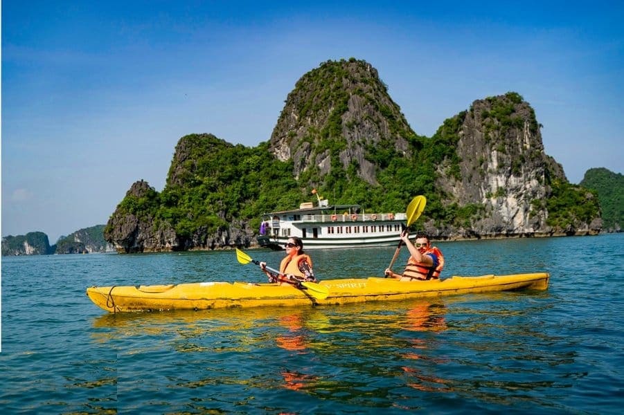 Tourists kayaking in Ha Long Bay, a popular activity for those traveling on the Sapa to Ha Long bus route